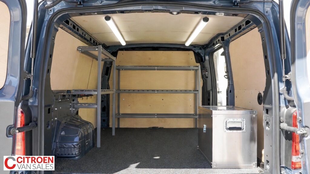 Crew cab van rear load area with ply lining, racking, and lockable tool storage illustrating common safe modifications.